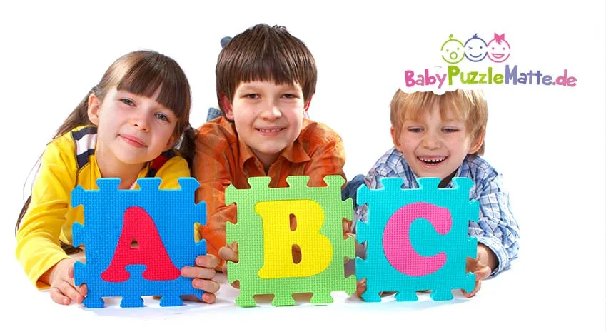 Kinder halten Puzzlematte ABC in den Händen hoch