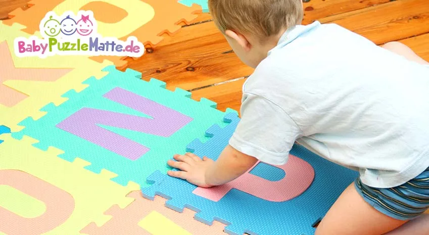 Wie sollte man eine Puzzlematte reinigen. Hier mit Kind beim auslegen der Puzzlematten Teile