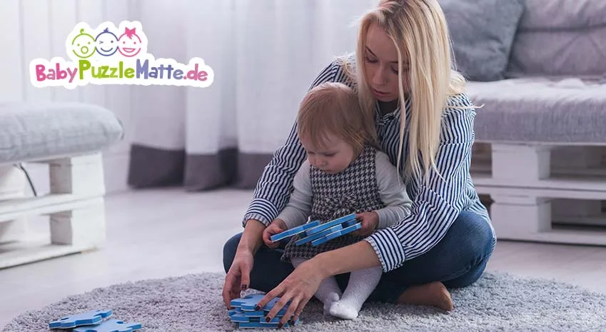 Mutter spielt mit ihrem Kind auf einer Puzzlematte zum aufrollen